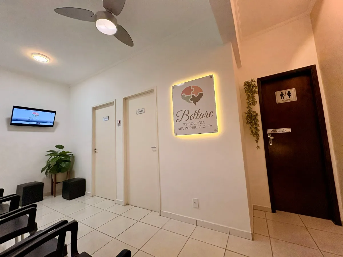Área de espera com o painel iluminado com o logo da Clínica Bellare